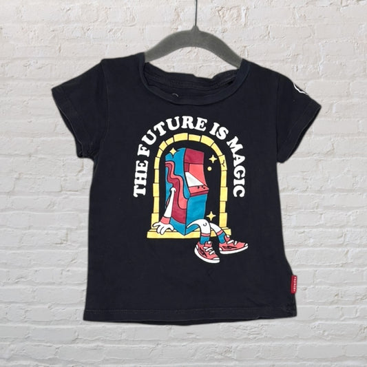 Black T-shirt with a colorful graphic and text 'The Future is Magic', featuring a whimsical design on a hanger.