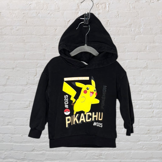 Black hoodie featuring a yellow Pikachu graphic with Pokémon branding, hanging on a hanger.