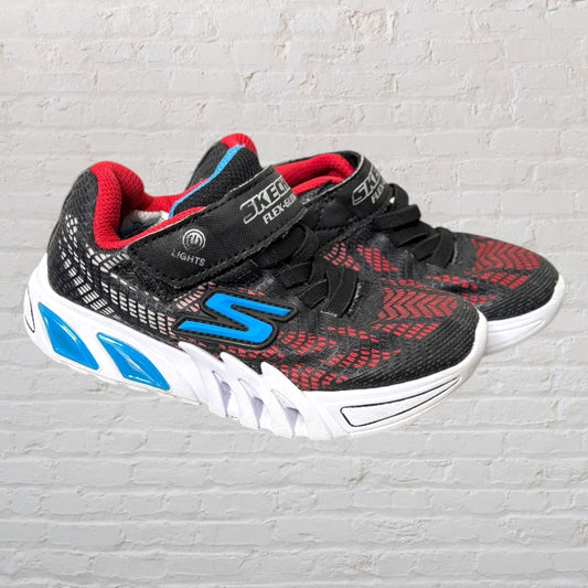 Skechers kids' sneakers in black with red and blue accents, featuring light-up soles.