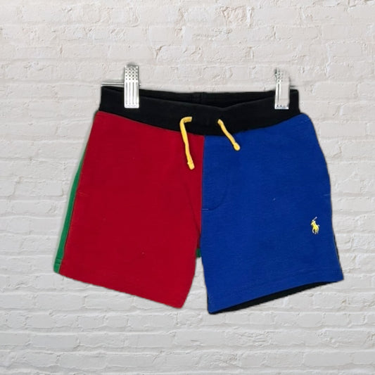 Unisex color-block shorts with red and blue panels, black waist, and yellow drawstring, featuring Polo Ralph Lauren logo.