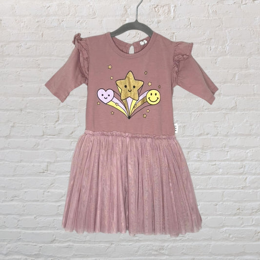 Dusty pink girls' dress with a star and smiley face graphic, featuring a tulle skirt and ruffled sleeves, displayed on a hanger.