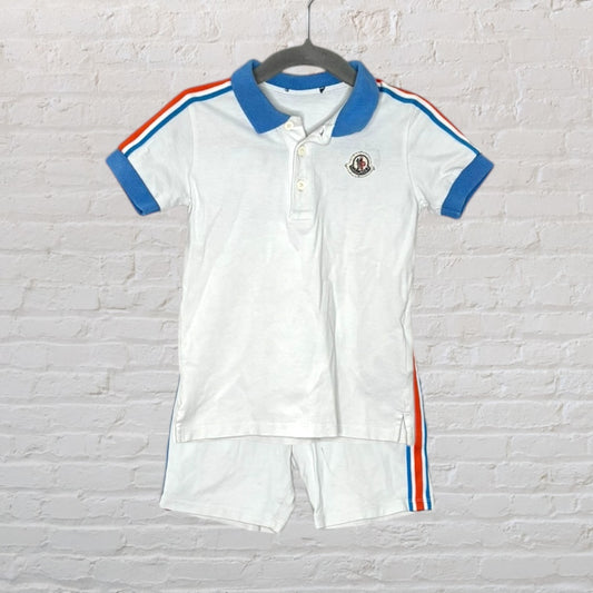 White polo shirt and shorts set with blue collar and cuffs, featuring red and blue stripes and an embroidered logo.