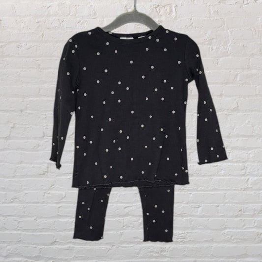 Black long sleeve polka dot outfit with matching leggings on a hanger, featuring white dots.