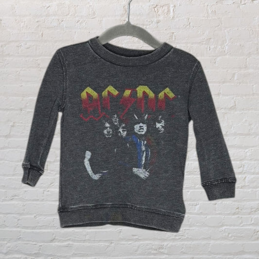 Dark gray AC/DC graphic sweatshirt featuring band members and logo, on a hanger against a brick background.