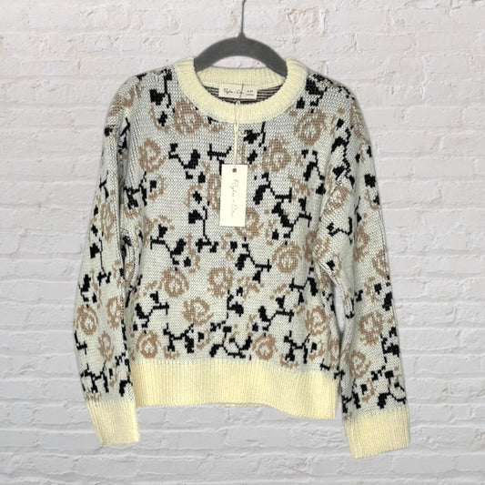 Cream and tan knit sweater with floral print design, hanging on a hanger with tag from Rylee + Cru.