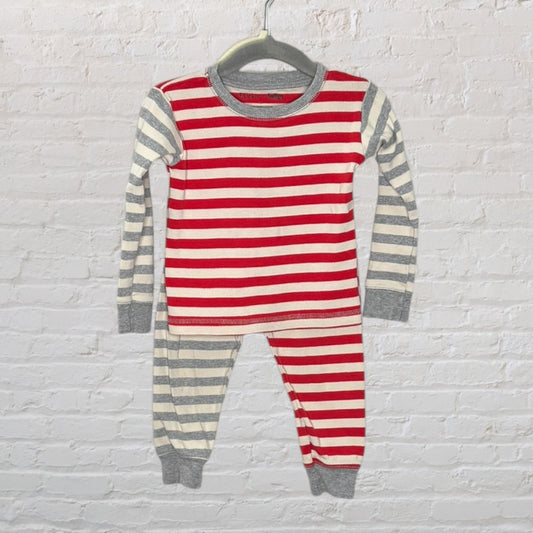 Unisex pajama set with red and white striped top and grey and white striped bottoms, displayed on a hanger.